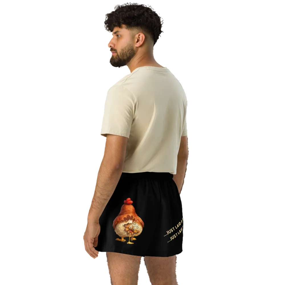 Man wearing a beige t-shirt and black shorts with a unique design on a white background